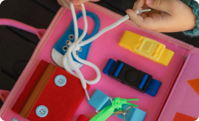 Small hands threading the laces on the Busy Board